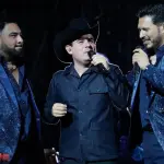 Alfredo Olivas cantando junto a Banda MS durante concierto en La Plaza México